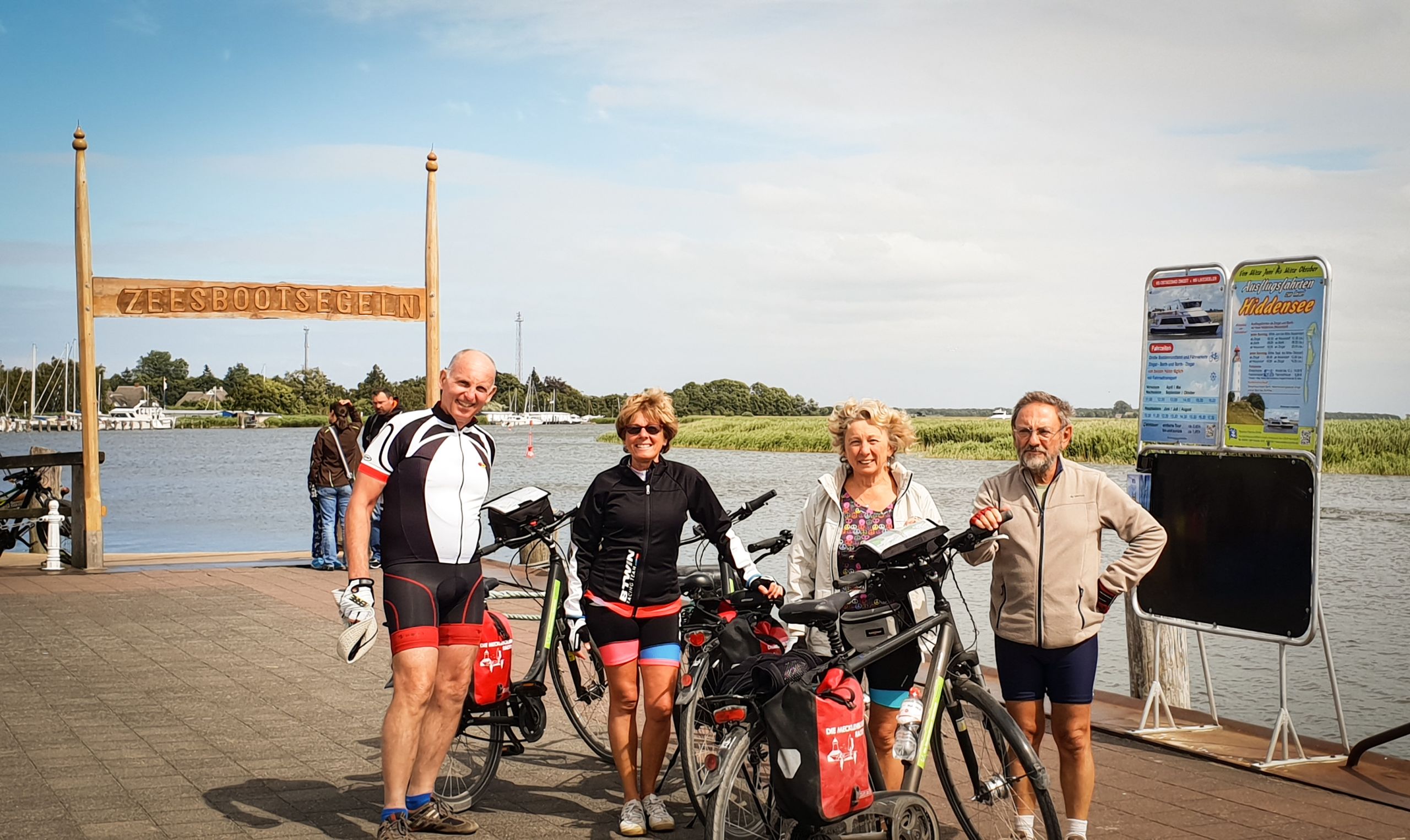 Gruppo di ciclisti in pausa vicino a un molo, ciclabile sul Mar Baltico, vacanze in bicicletta
